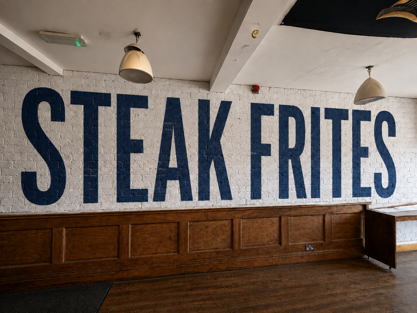 Steak Frites mural painted on a white brick wall